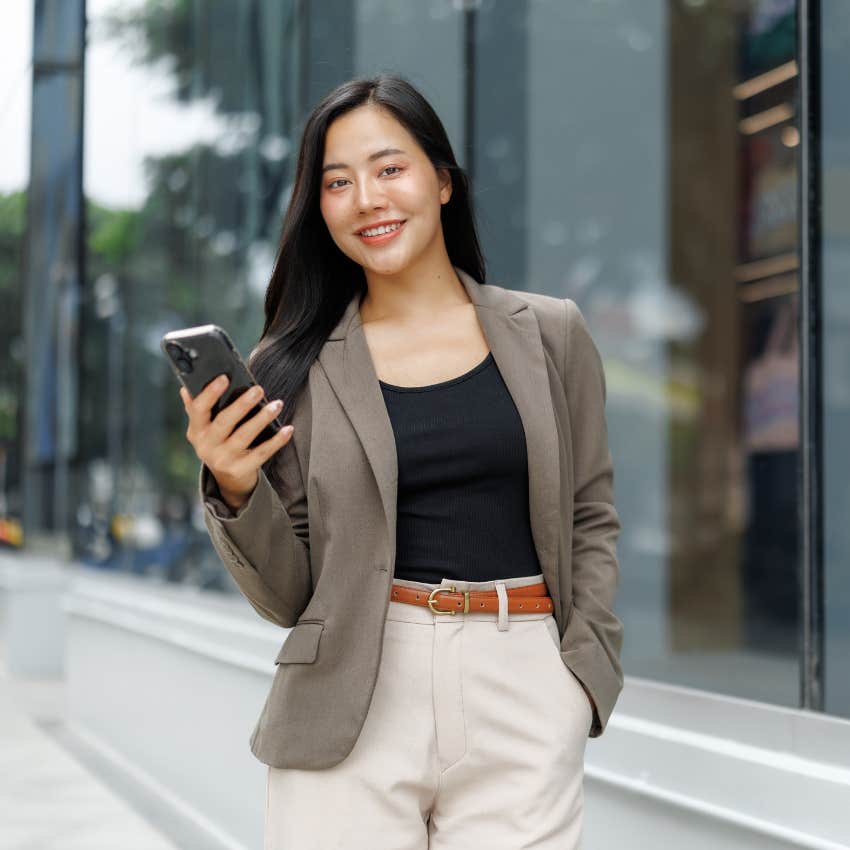 insecure woman holding phone trying to look rich in public