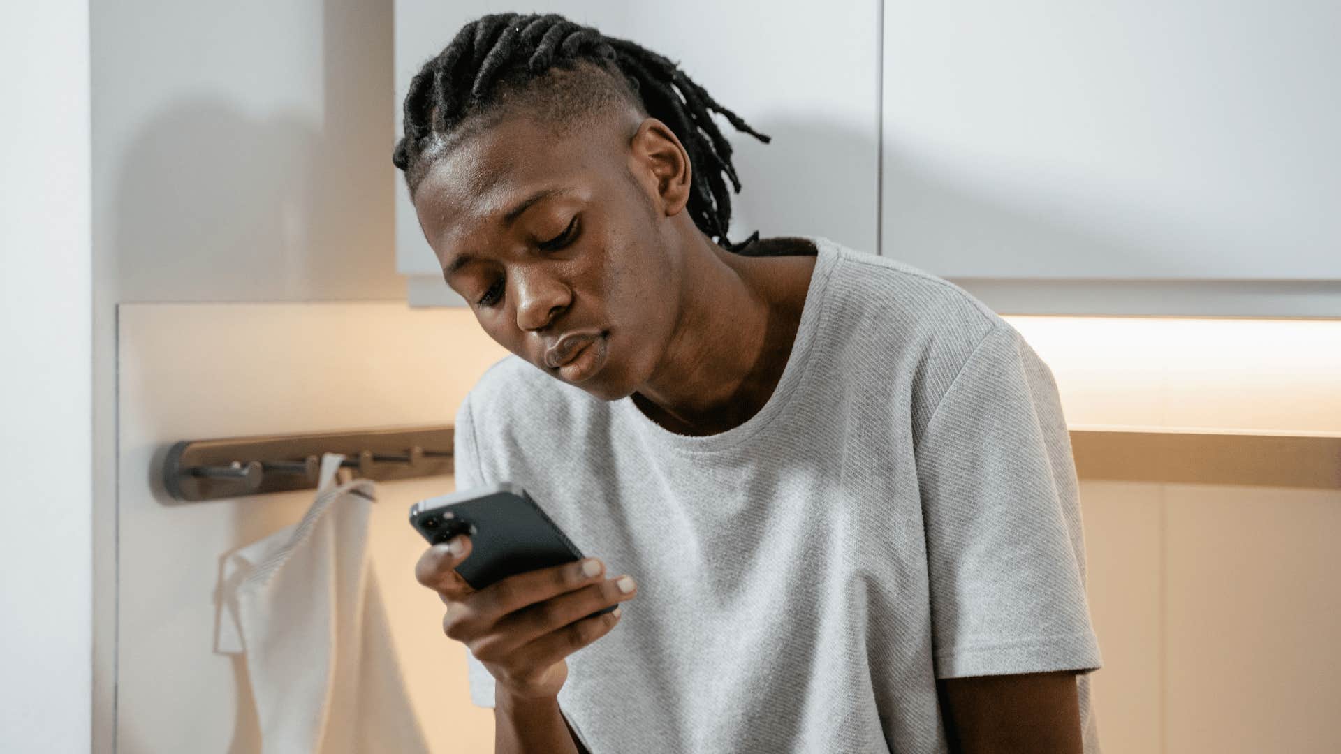 gen Z man looking at his phone struggling with social comparison to others