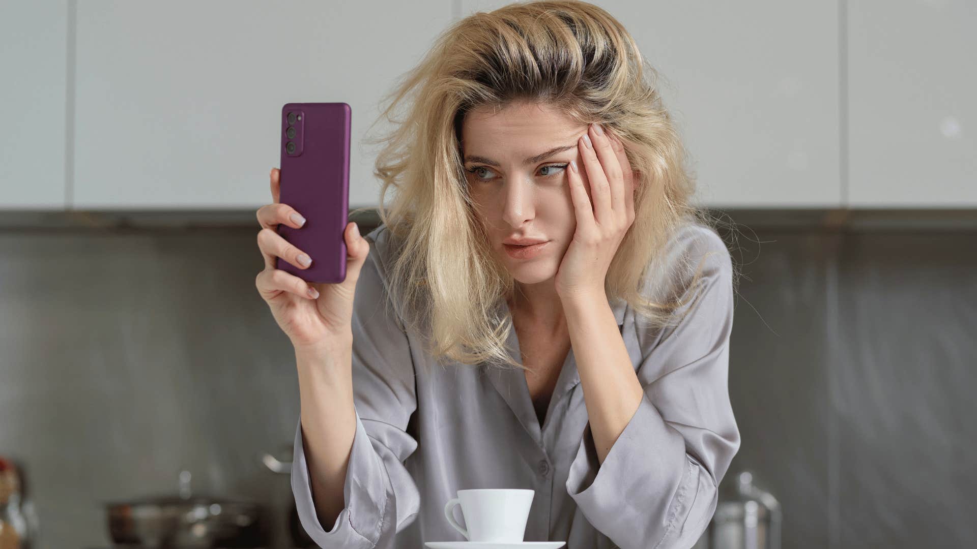woman tired looking at phone as she thinks it must be nice