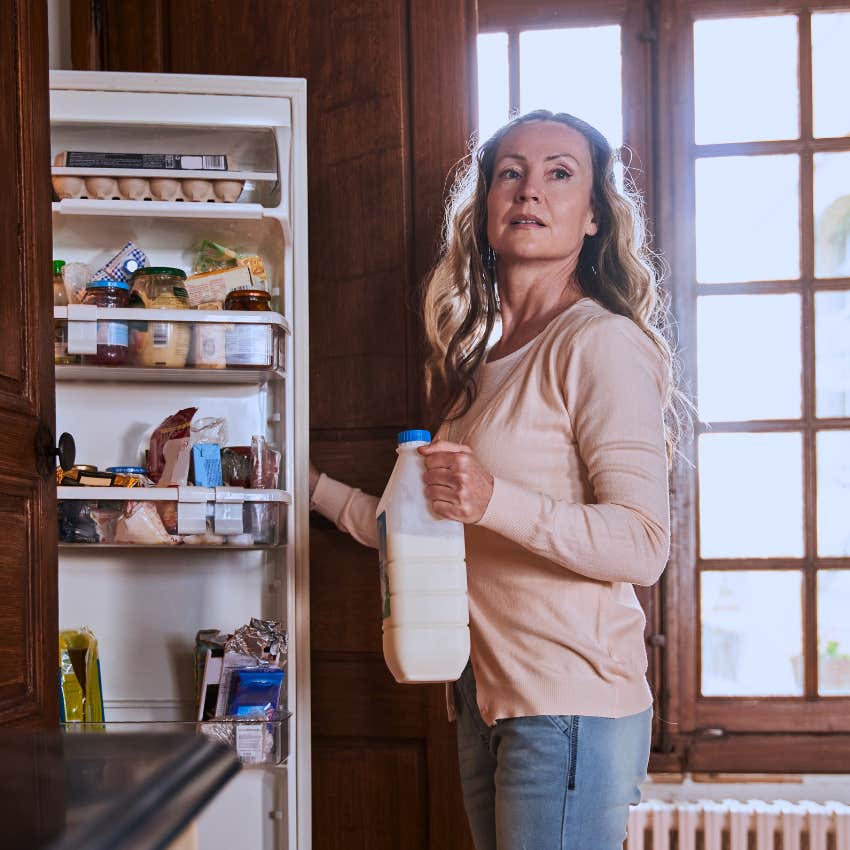 gen X woman planning dinner opening her fridge at home