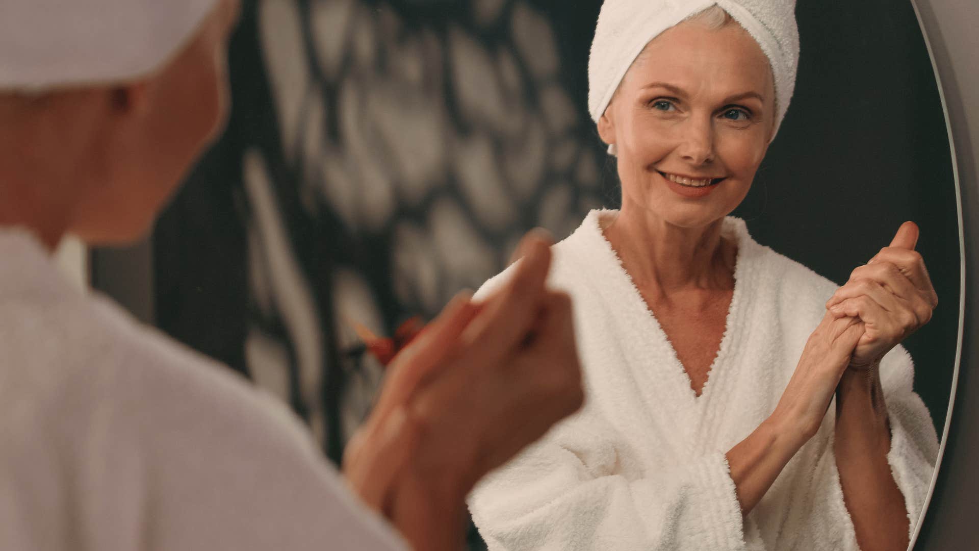 gorgeous boomer woman smiling in the mirror