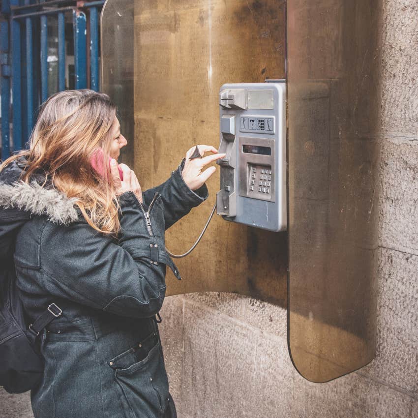 woman using a payphone because she can't easily check in with people