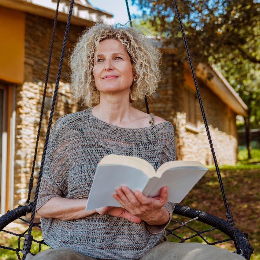 gen X woman sitting outside reading as a hobby