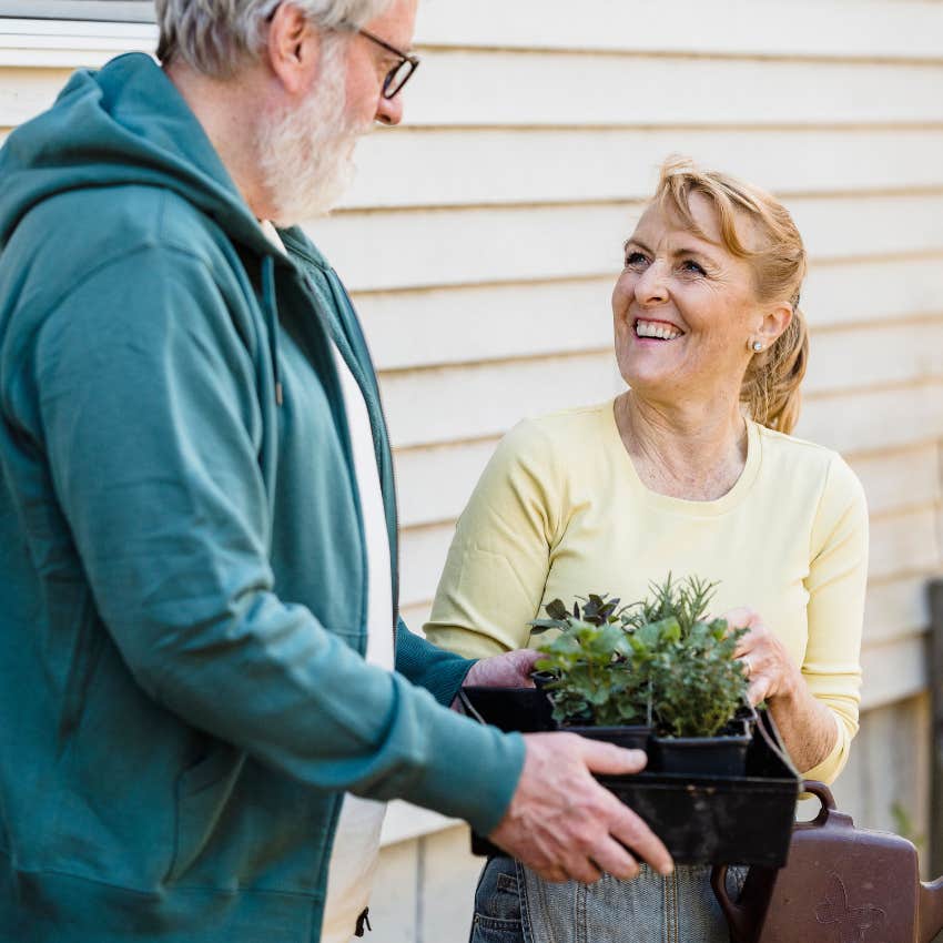 gen X woman talking to neighbor bringing her flower bed