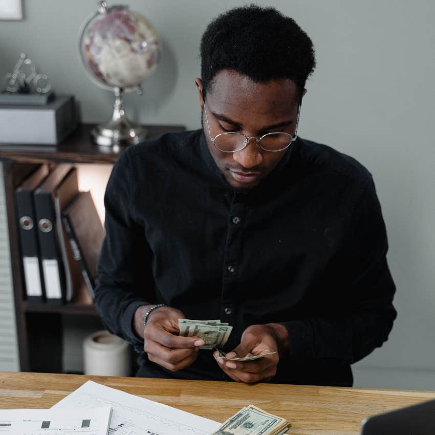 millennial man budgeting his money at home