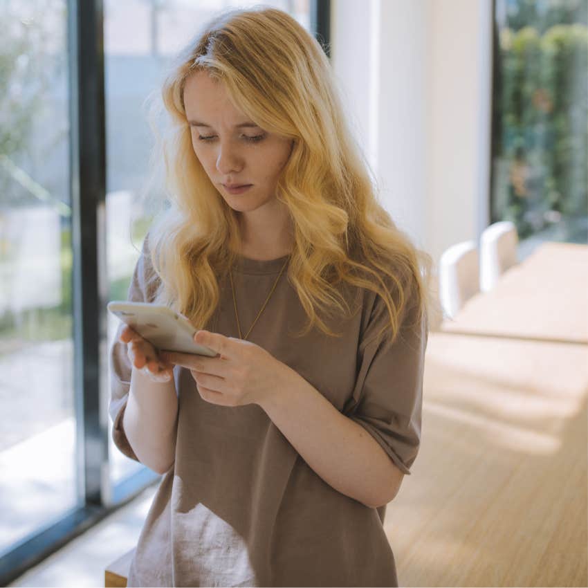 thoughtful young woman looking at her phone not following trends