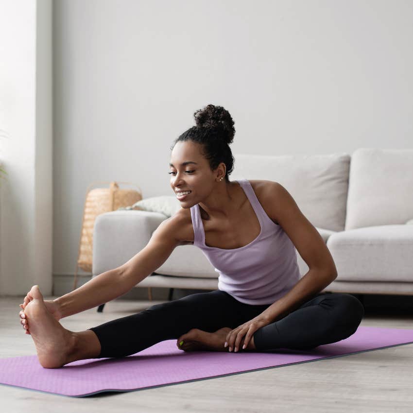 high-strung woman practicing yoga in her living room to calm down fast