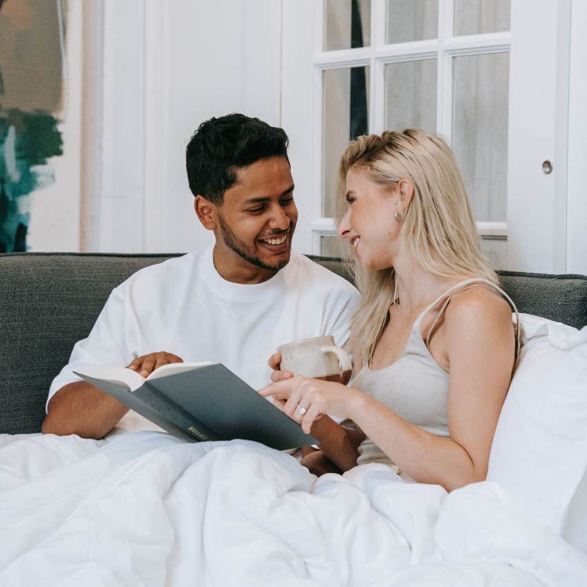 couple sitting on the couch reading a book together