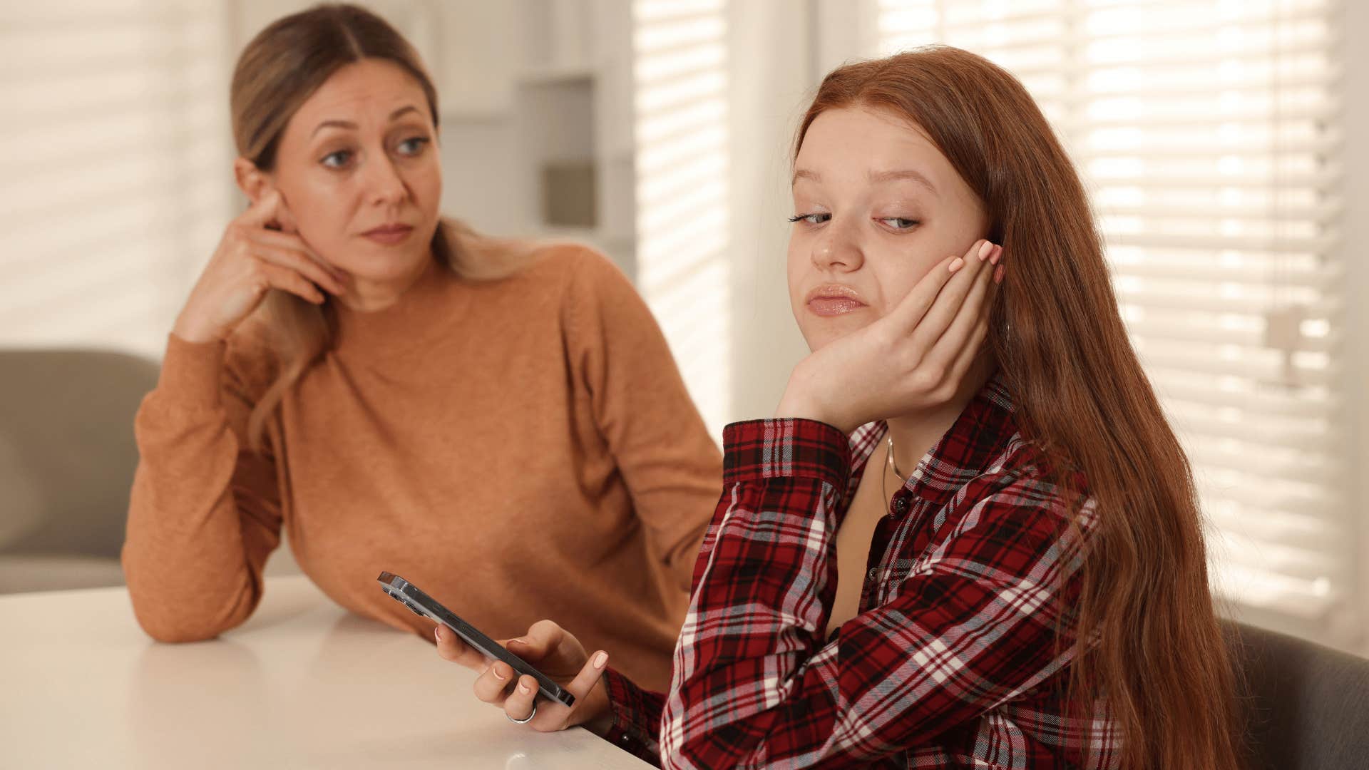 mother looking annoyed talking to daughter with an attitude