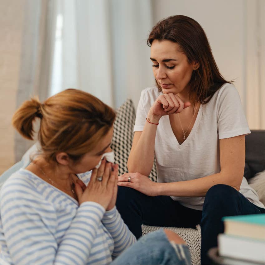 Adult woman looking surprised and uncomfortable as a friend patiently listens to her