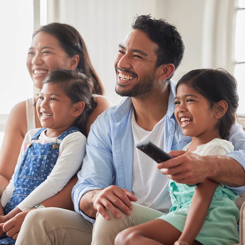 parents watching television with their young girls
