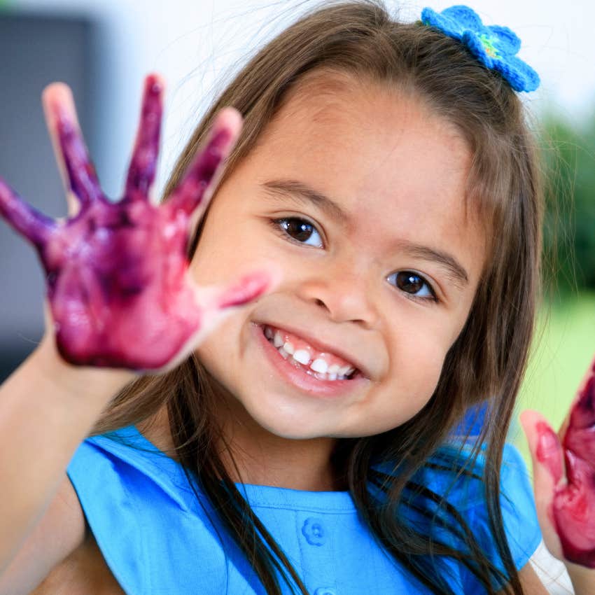 creative kid with paint all over her hands