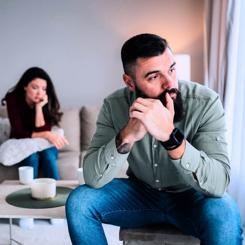 man with a bad childhood avoiding commitment sitting away from partner