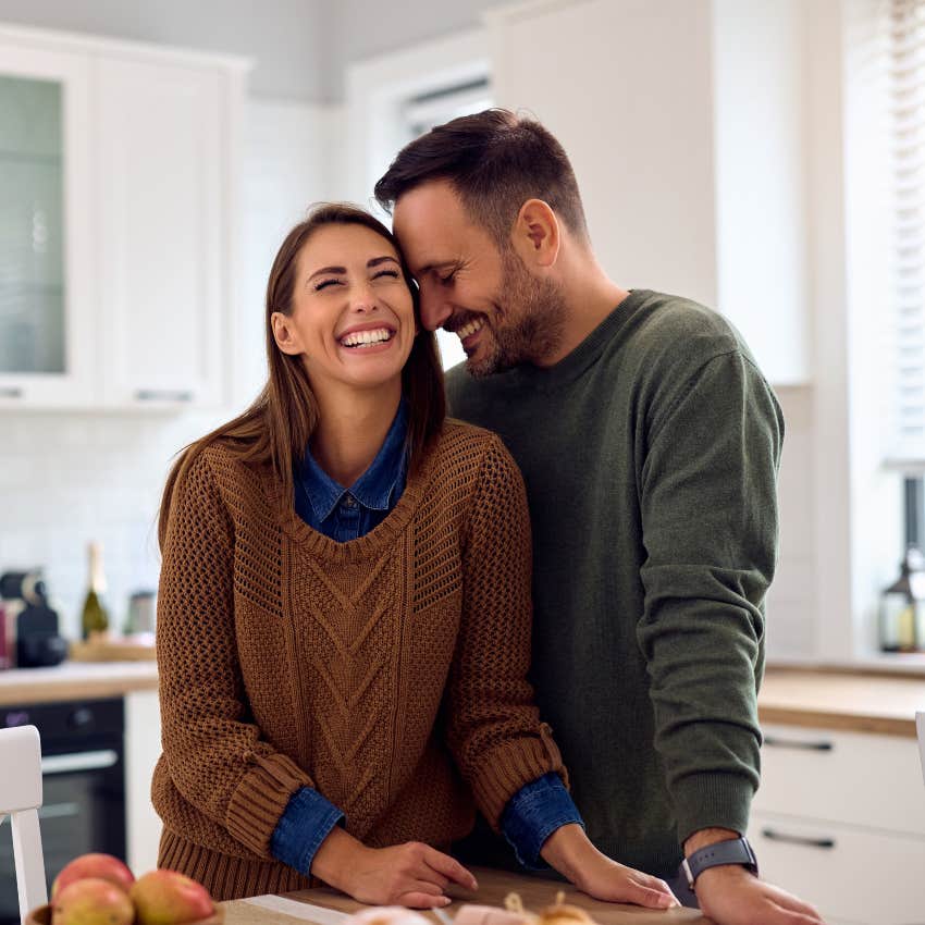 couple smiling being affectionate with each other in the kitchen