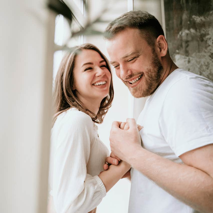 man lovingly holding a woman's hand to his chest