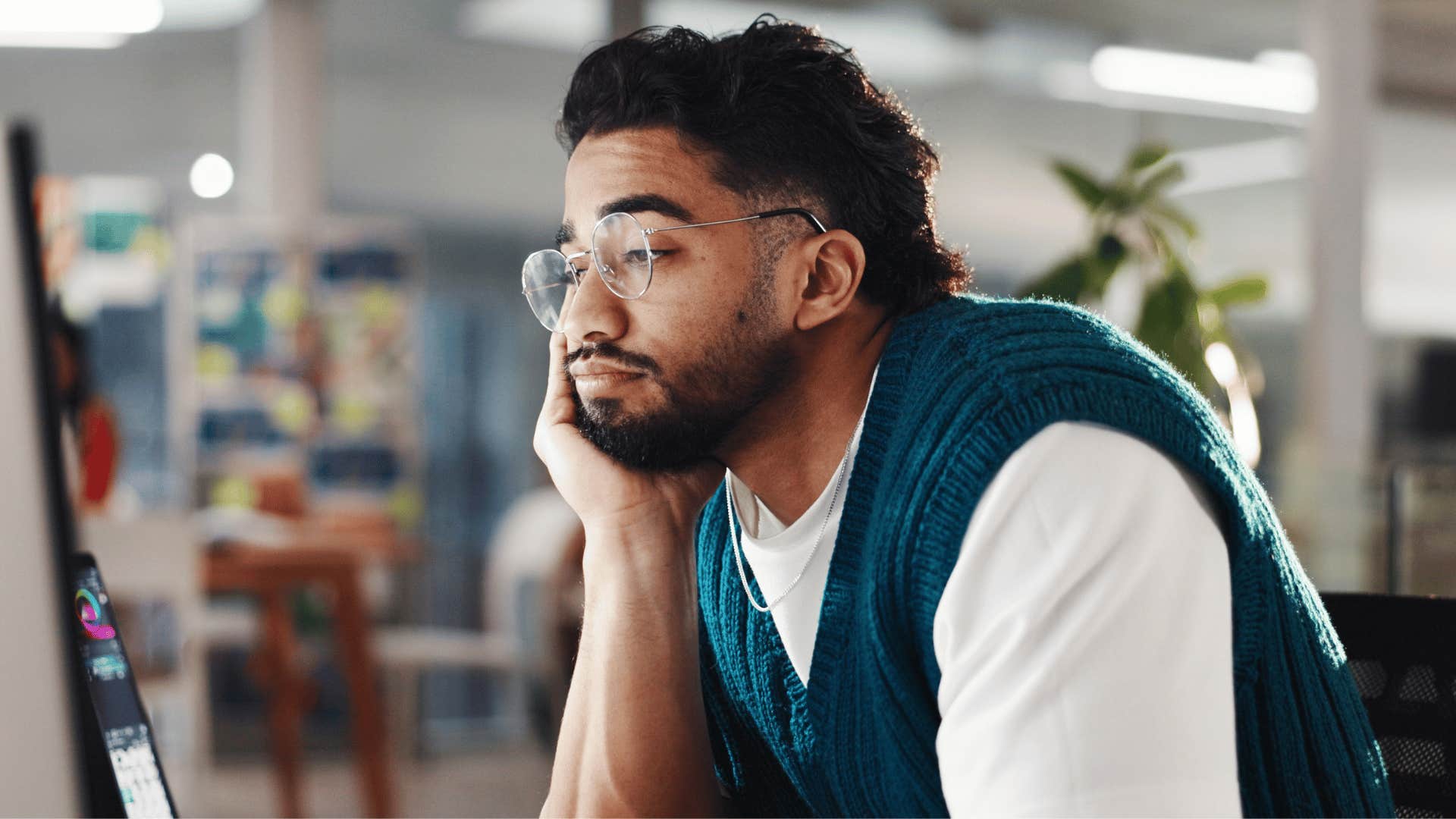 man staring at laptop bored as he thinks i'll deal with it later
