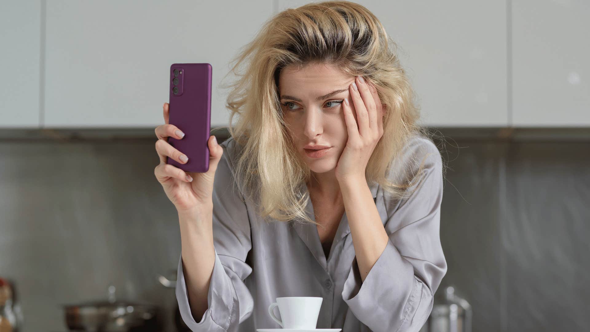 woman staring at the phone annoyed as she thinks i'm so tired of people