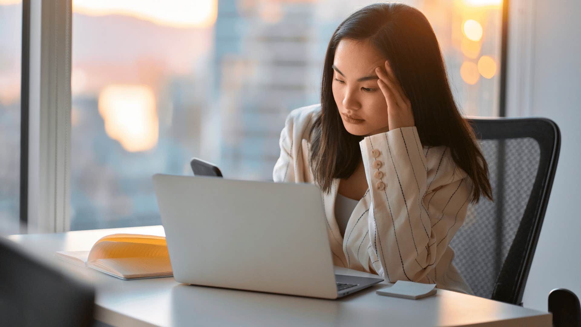 woman fed up at work staring at laptop as she thinks i don't feel like talking right now