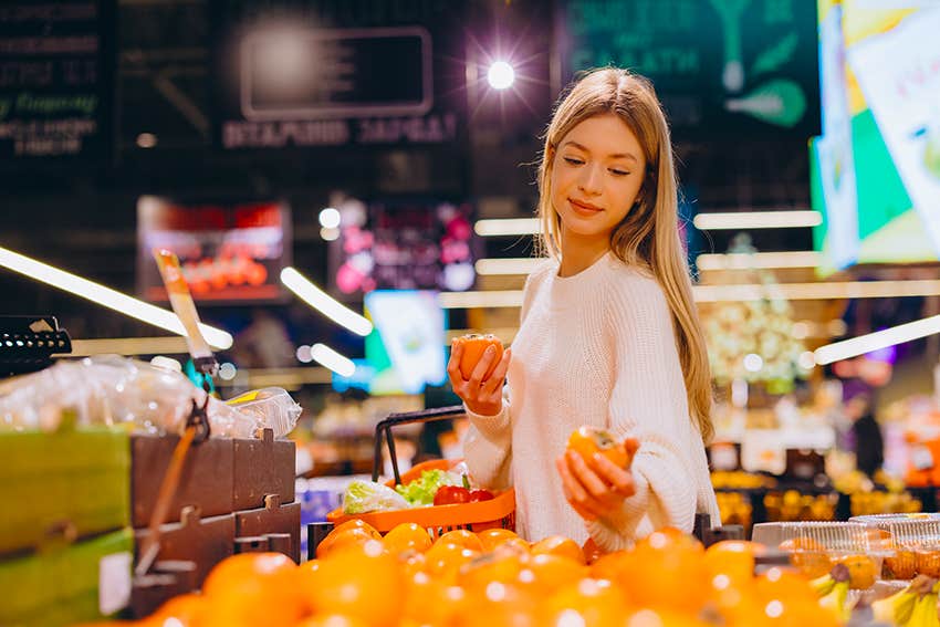 younger woman treating groceries like a splurge because basic necessities have become unaffordable 