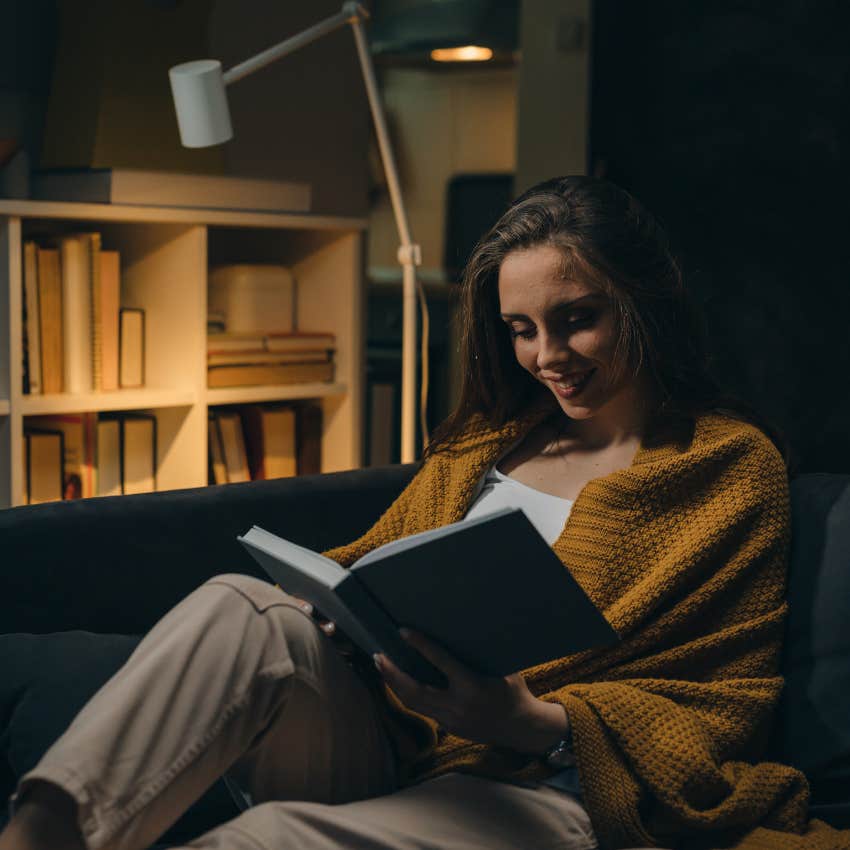 woman with intellectual curiosity reading in home filled with physical books