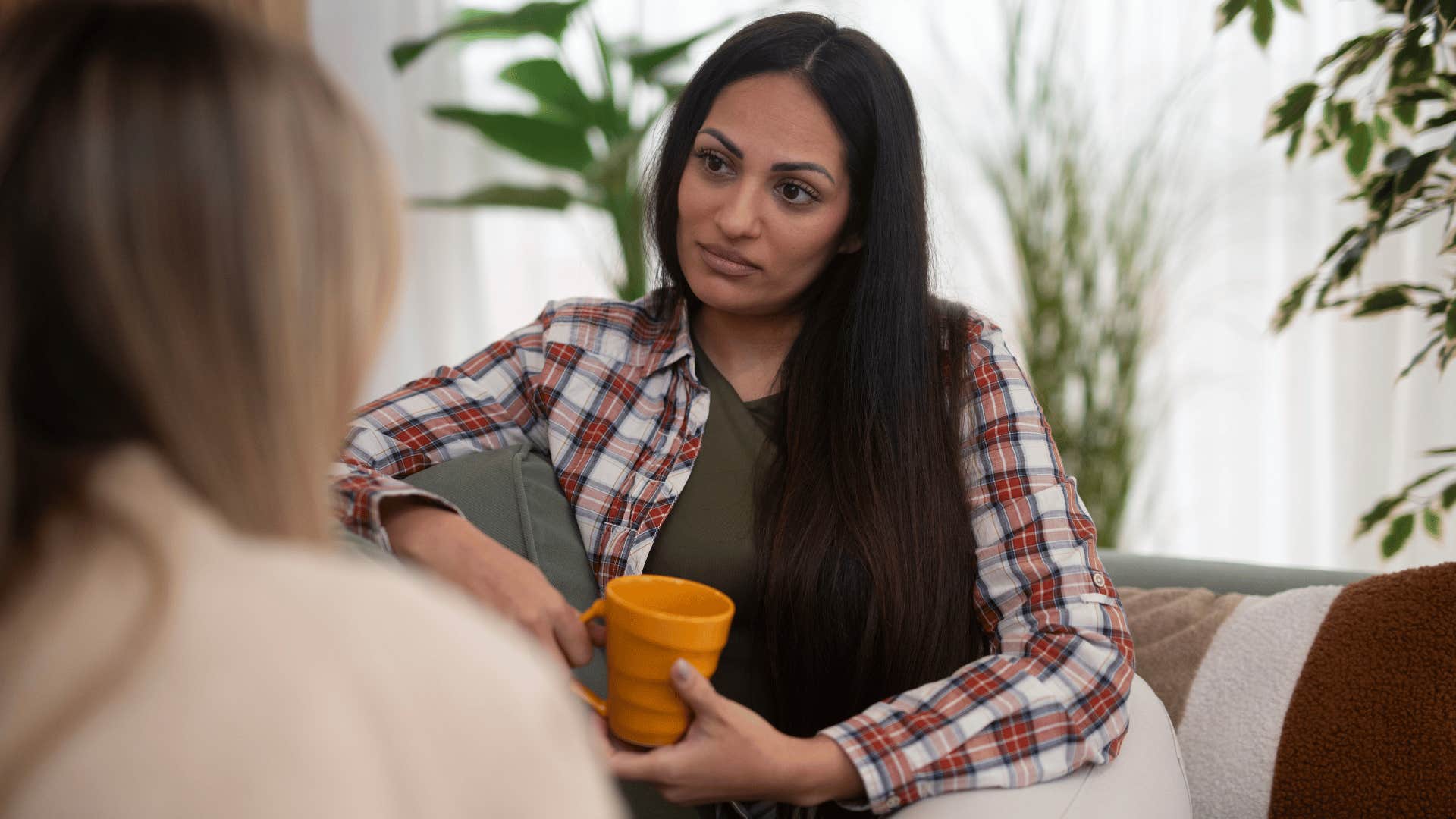 friend in gray shirt listening to friend as she secretly thinks i'd rather keep the peace so i'm not going to say anything