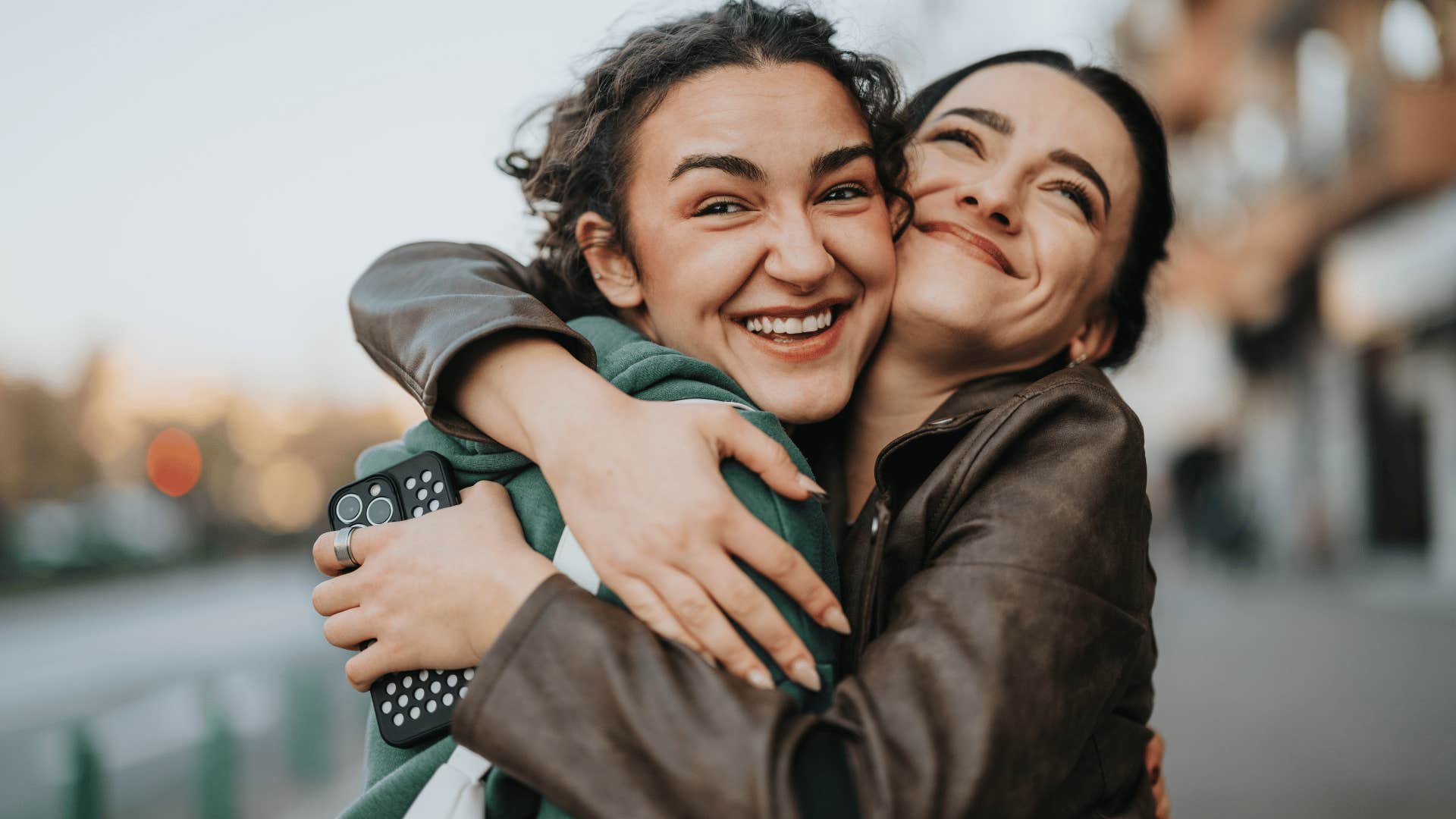 friends hugging as friend in brown jacket says don't stress it'll work itself out