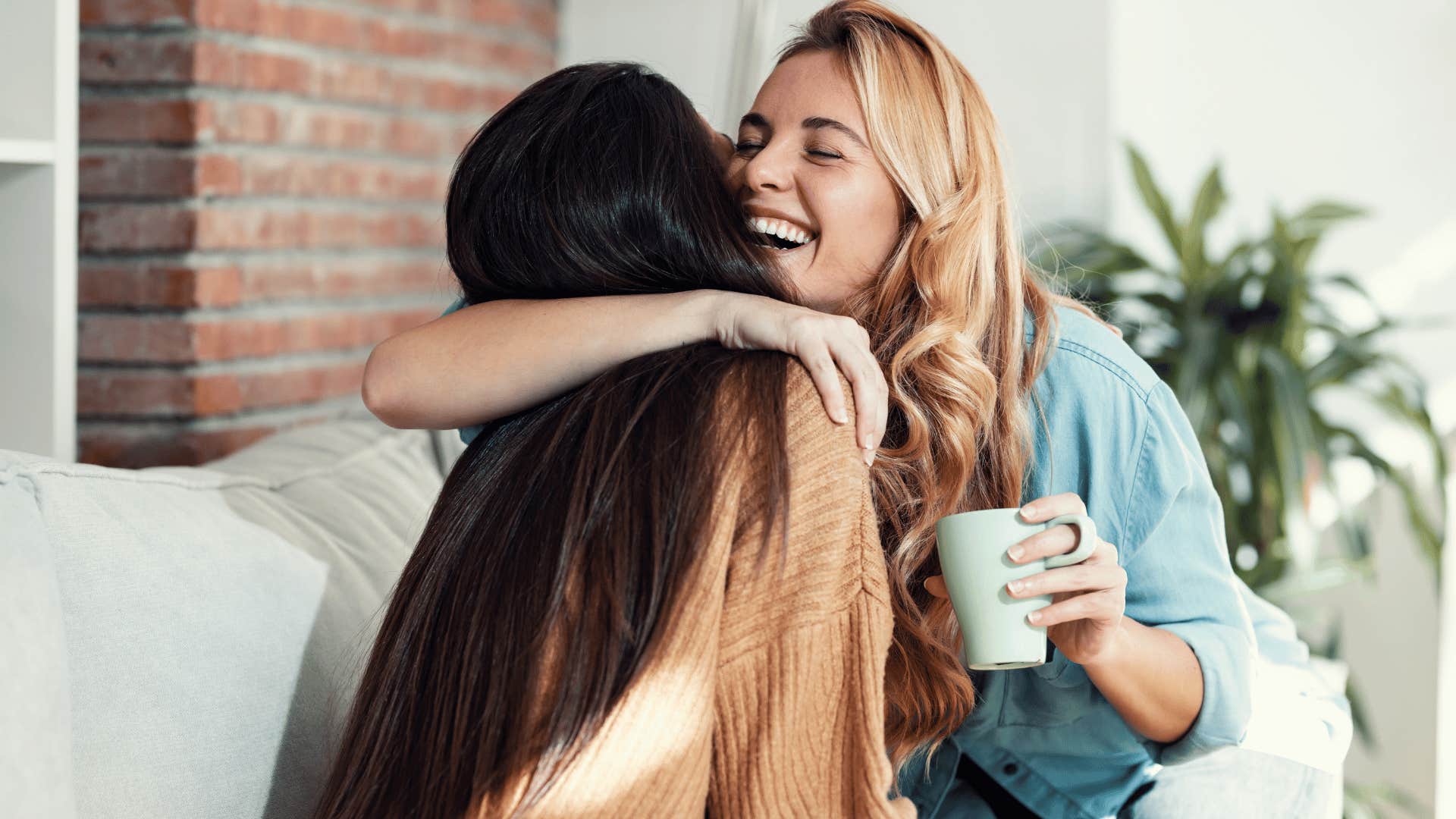 woman hugging friend smiling as she says that's okay i understand