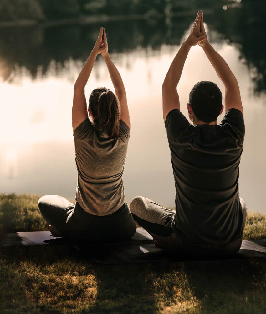 two people who don't like social media doing yoga outdoors by a lake