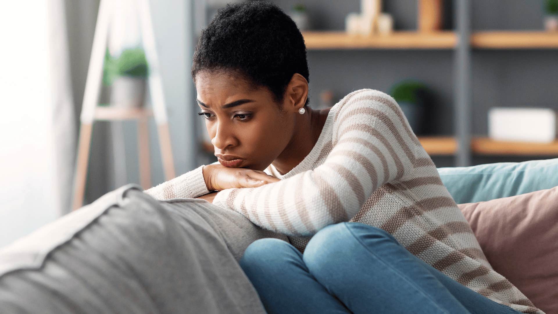 woman in stripped shirt upset on couch as she thinks i do so much but nobody ever appreciates me