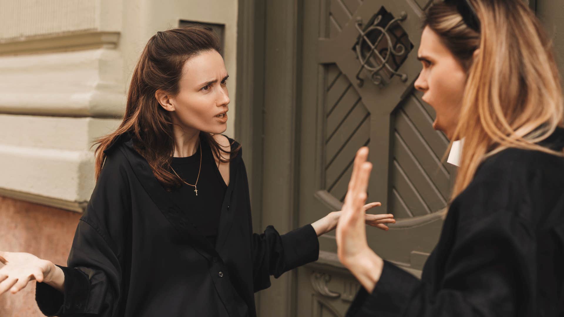 woman in black shirt telling friend you're being selfish as friend looks offended