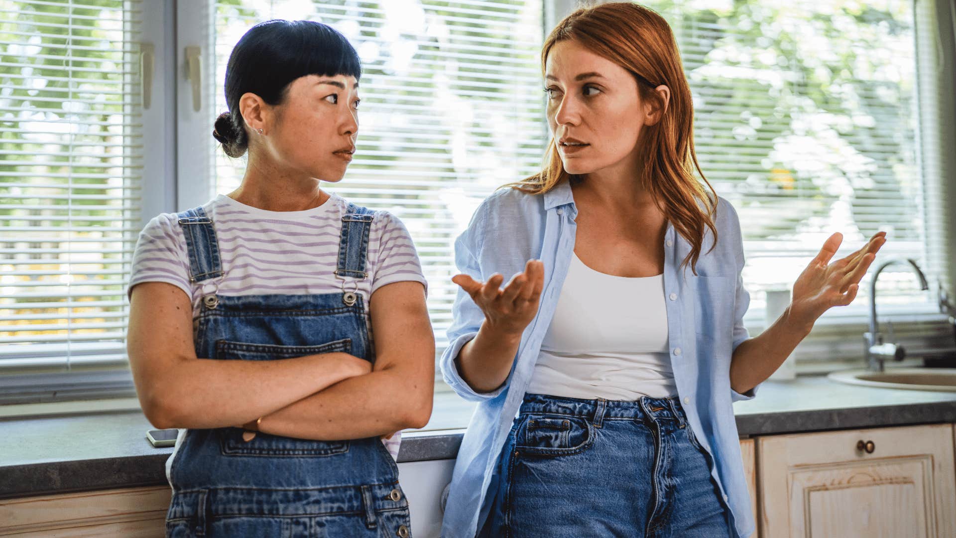 blonde woman tells woman with black hair i'll apologize when i feel like it