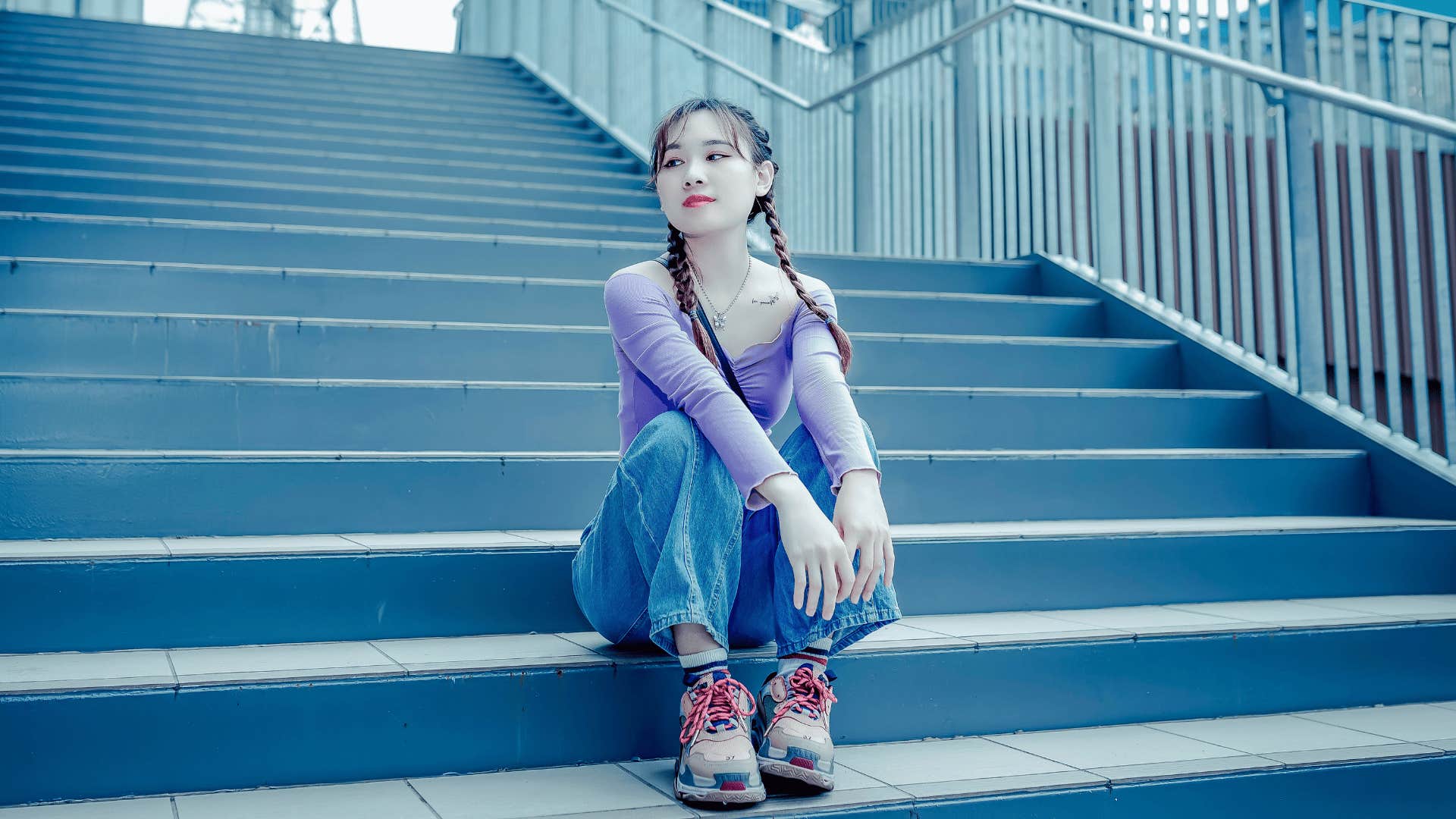 gen Z woman on a stair case wearing chunky sneakers