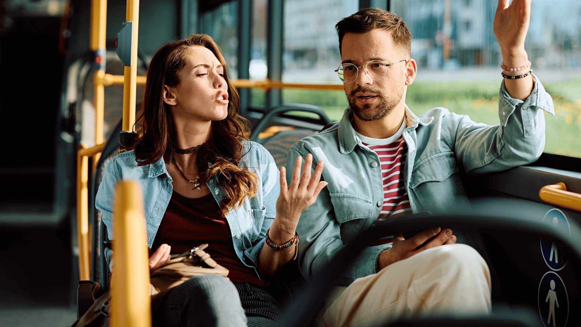 couple arguing on the bus as man says calm down you're overreacting