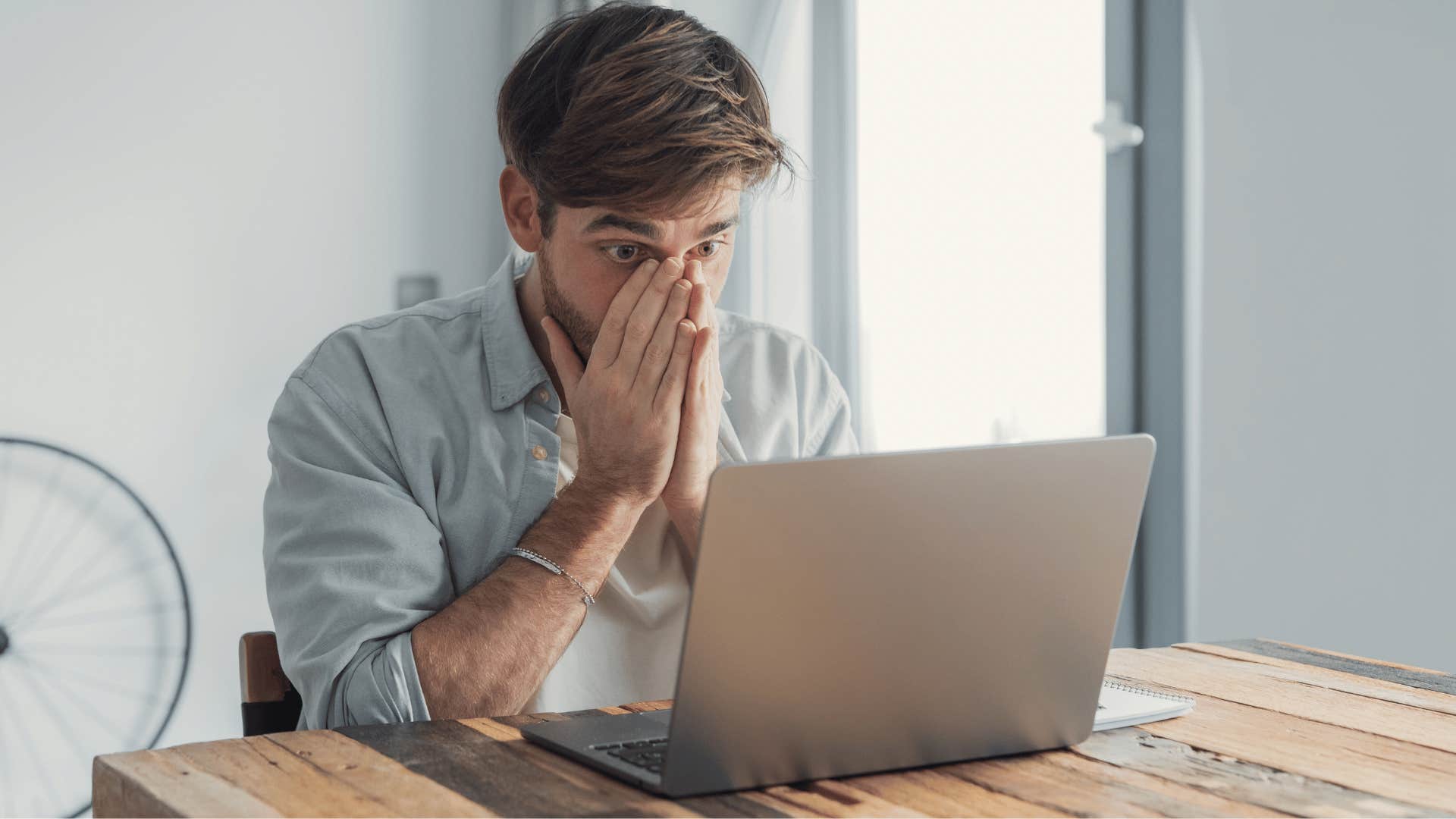 man looking scared at laptop as he thinks i didn't really think it through