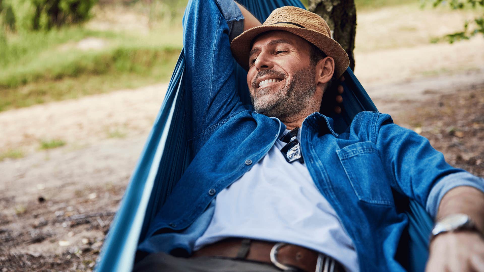 man in white shirt and brown hate relaxing as he thinks i literally couldn't care less
