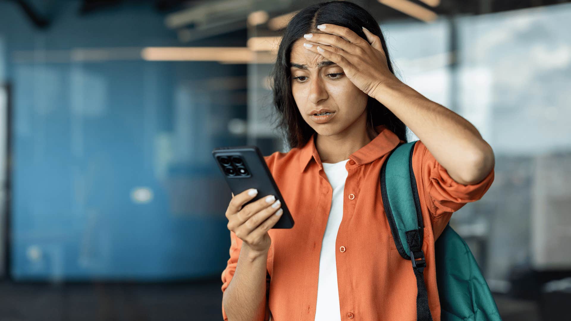 woman in orange jacket stressed at phone as she thinks i'm bad at talking to people