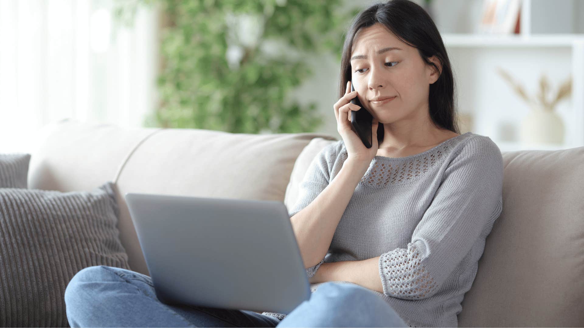 woman in gray shirt annoyed on the phone as she thinks let me stop talking