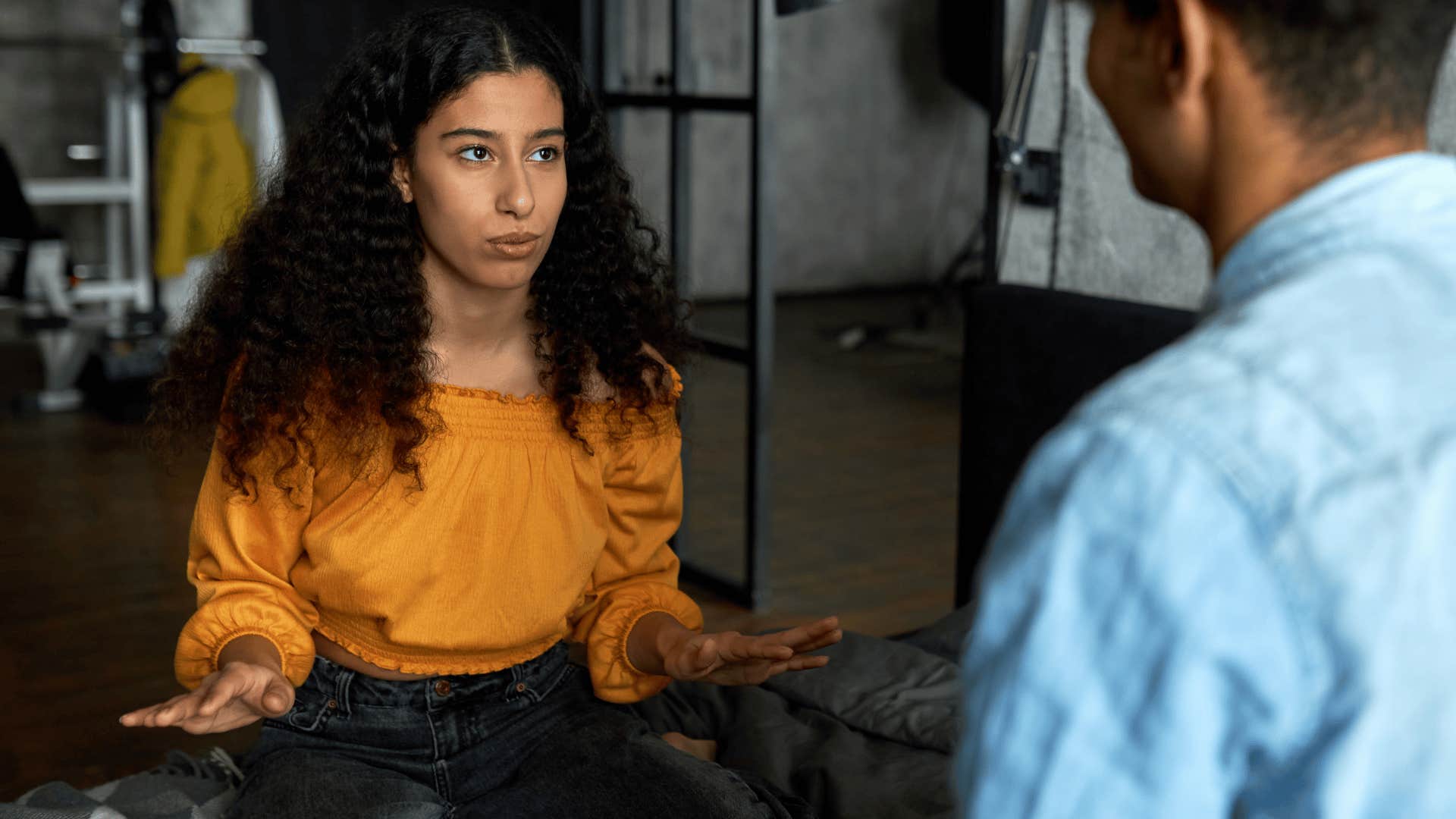 woman in orange shirt telling man please ignore me