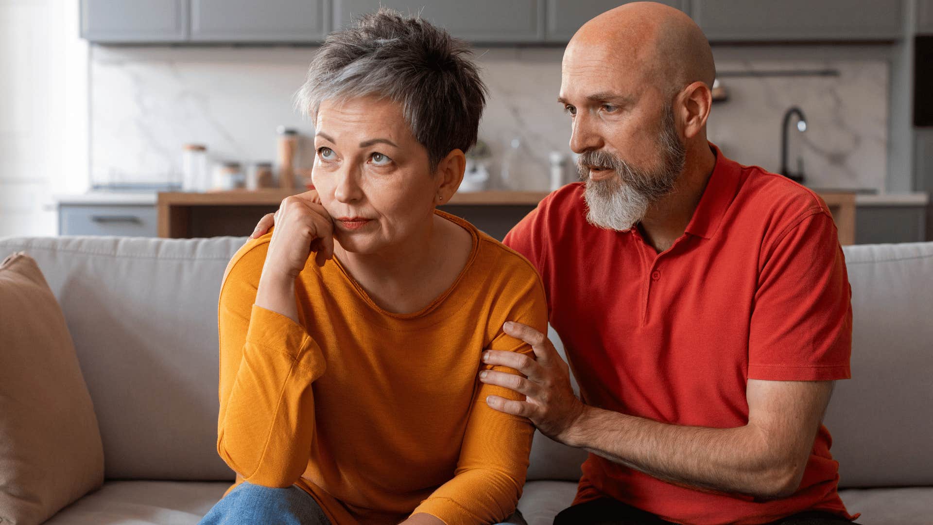 man in red shirt comforting woman as he says sorry that sounded wrong