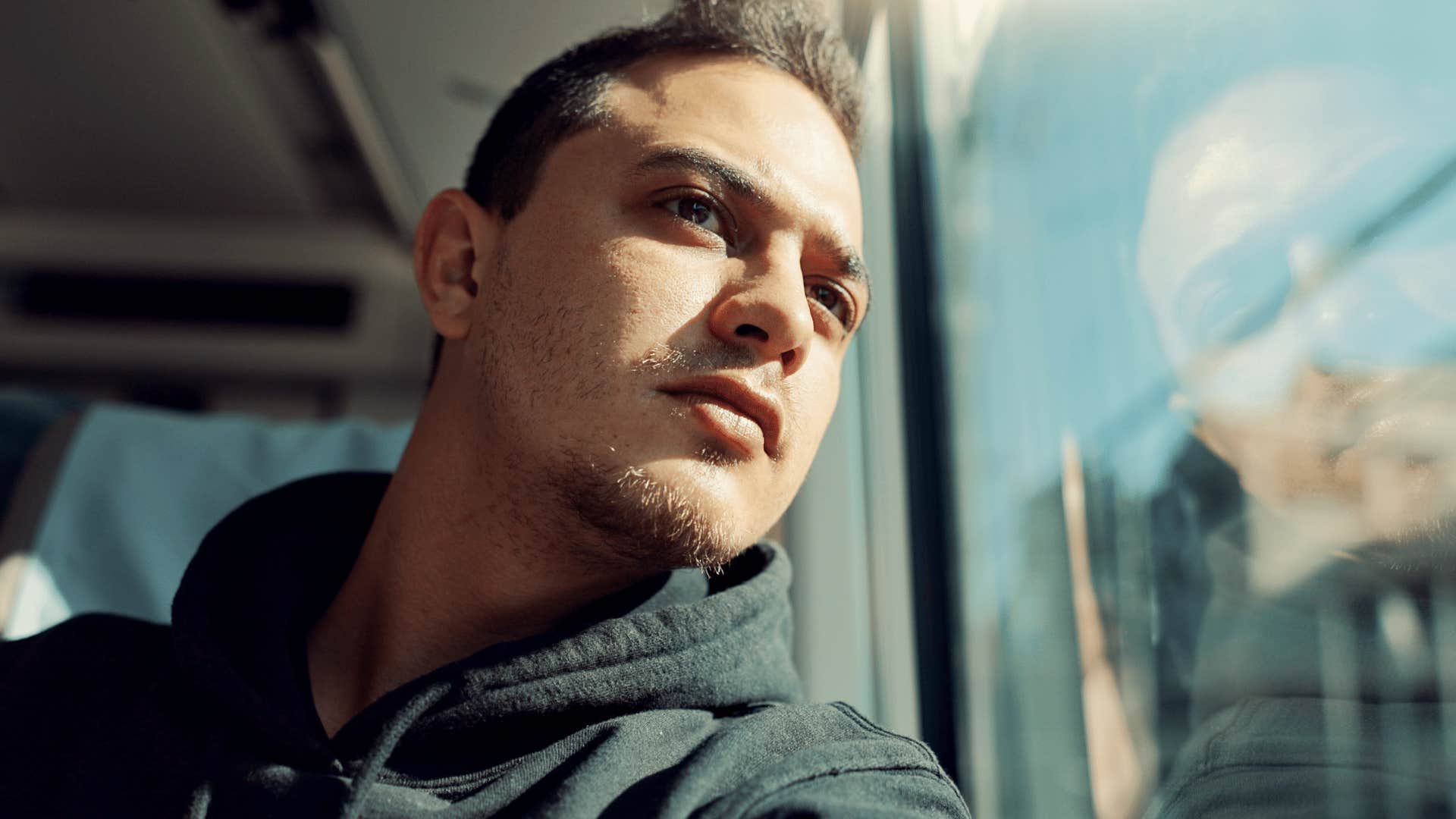 man looking out the window of bus as he thinks i just need a break from everything