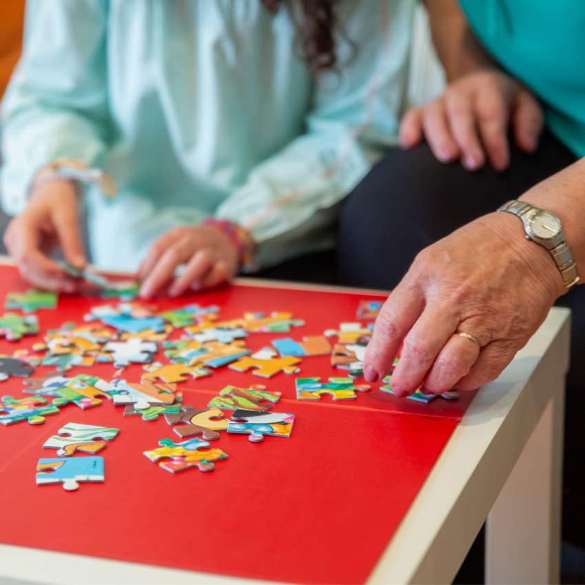older couple sitting working together on a large jigsaw puzzle