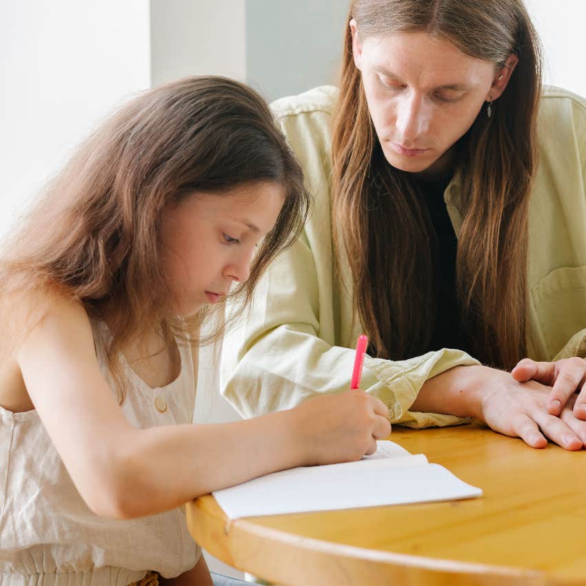 Parent encouraging a frustrated child to solve a problem independently while offering quiet support