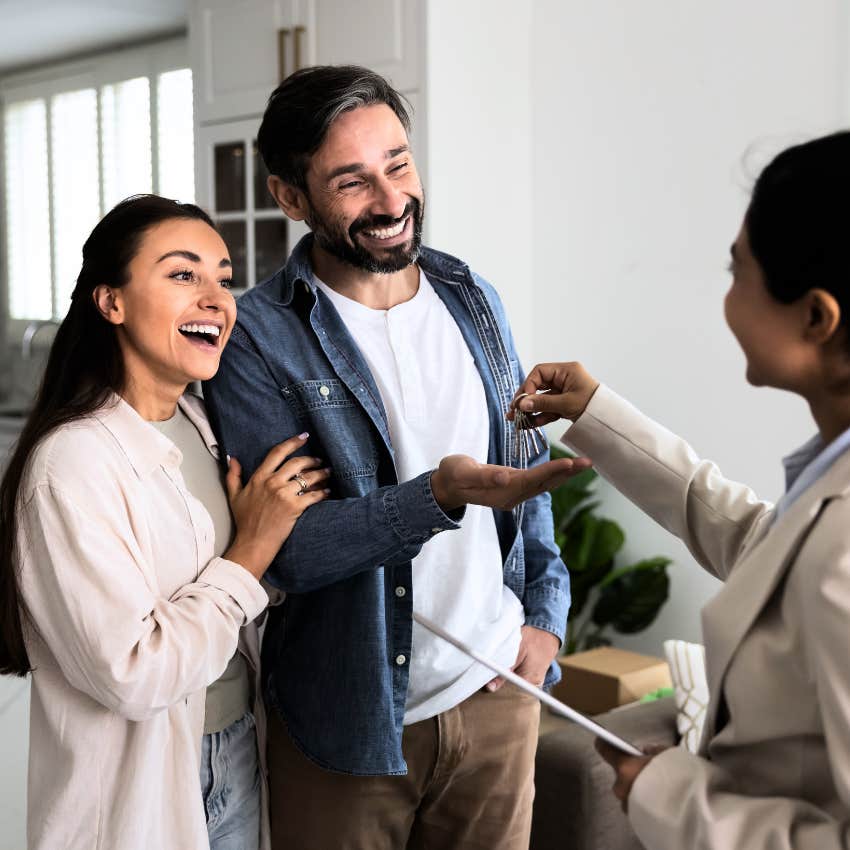 Couple owning a home and taking the keys from a woman. 