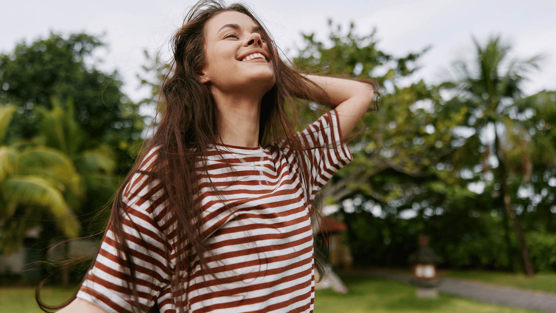woman in stripped shirt smiling brightly as she has a contagious personality