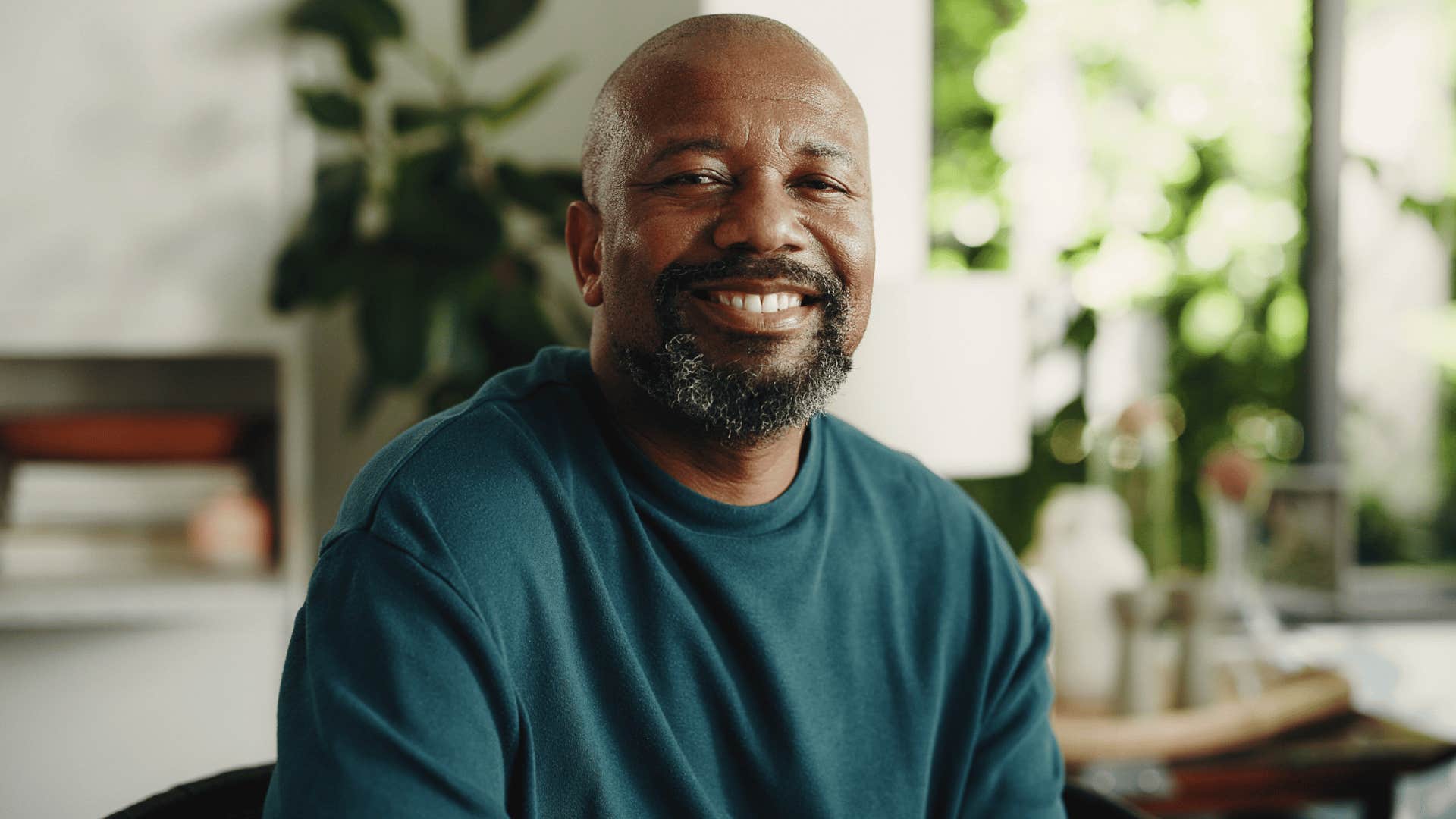man in blue shirt smiling as he has a strong sense of identity