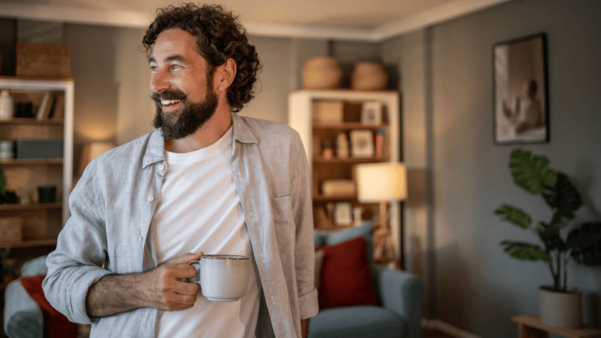 man in white shirt drinking coffee as he smiles brightly with authenticity