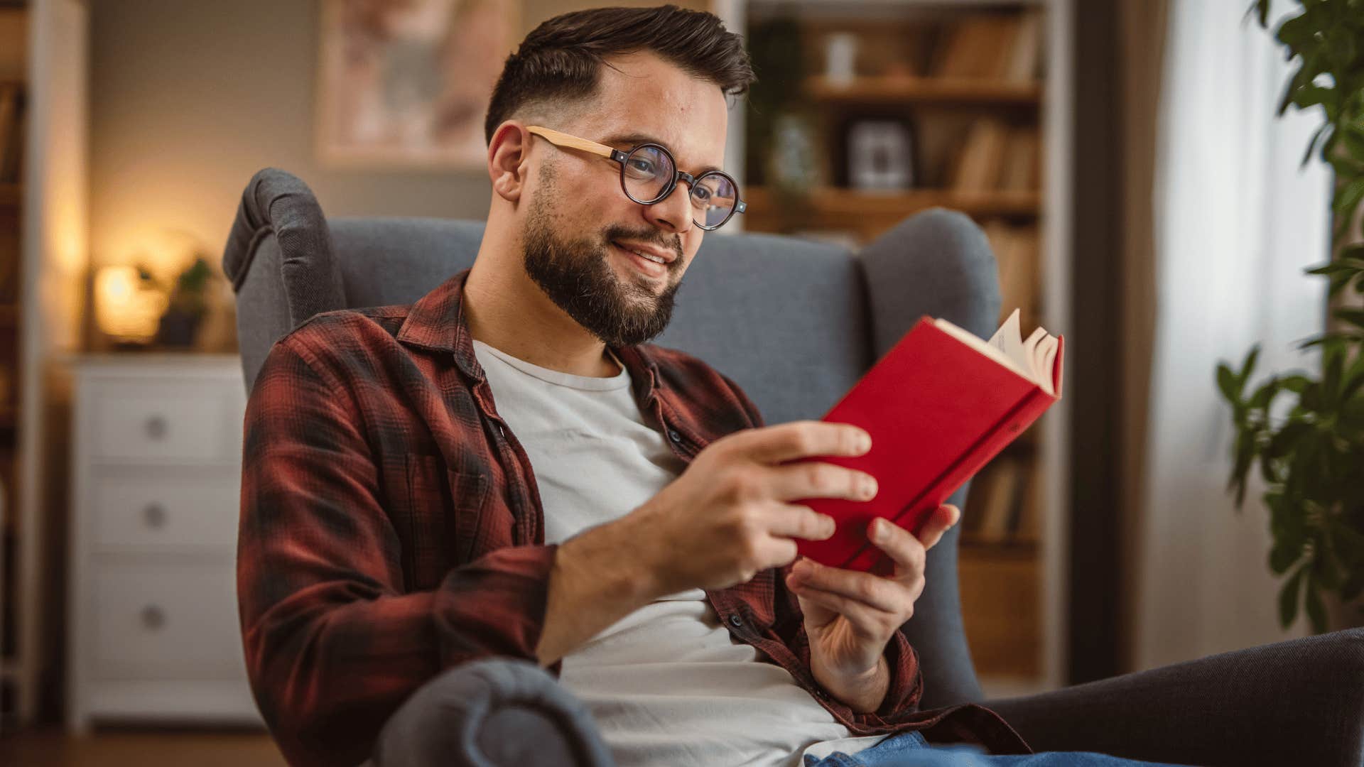man in white shirt having a designated spot for reading and relaxing as he reads book