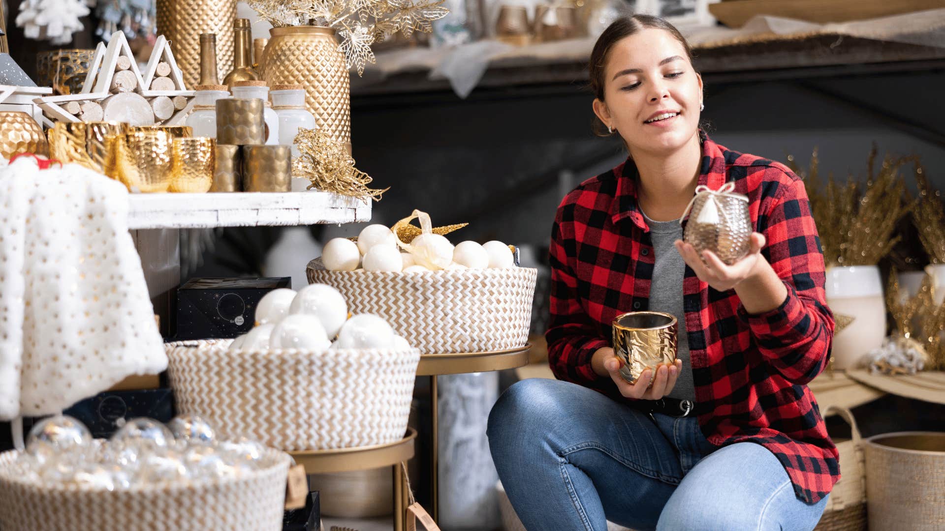 woman in plaid shirt picking up tons of candles in store