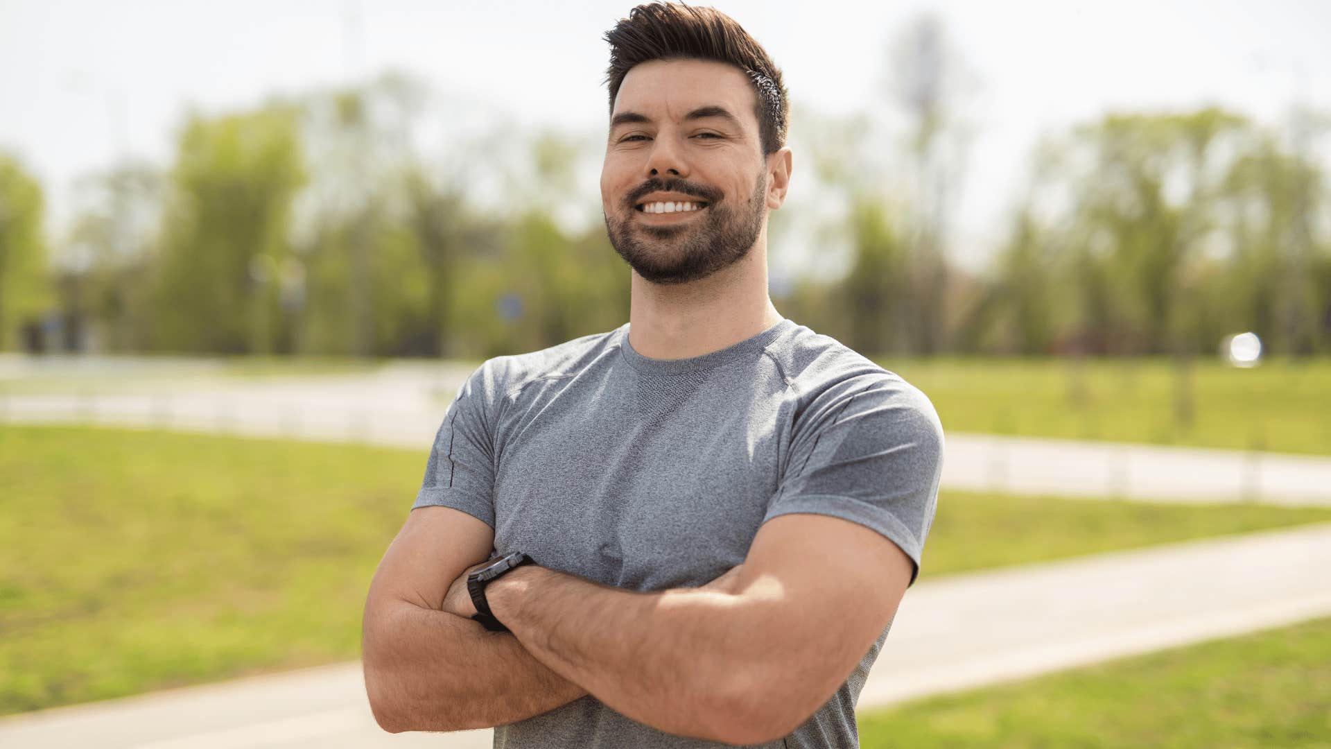 man in gray shirt crossing arms as he smiles and says i am who i am