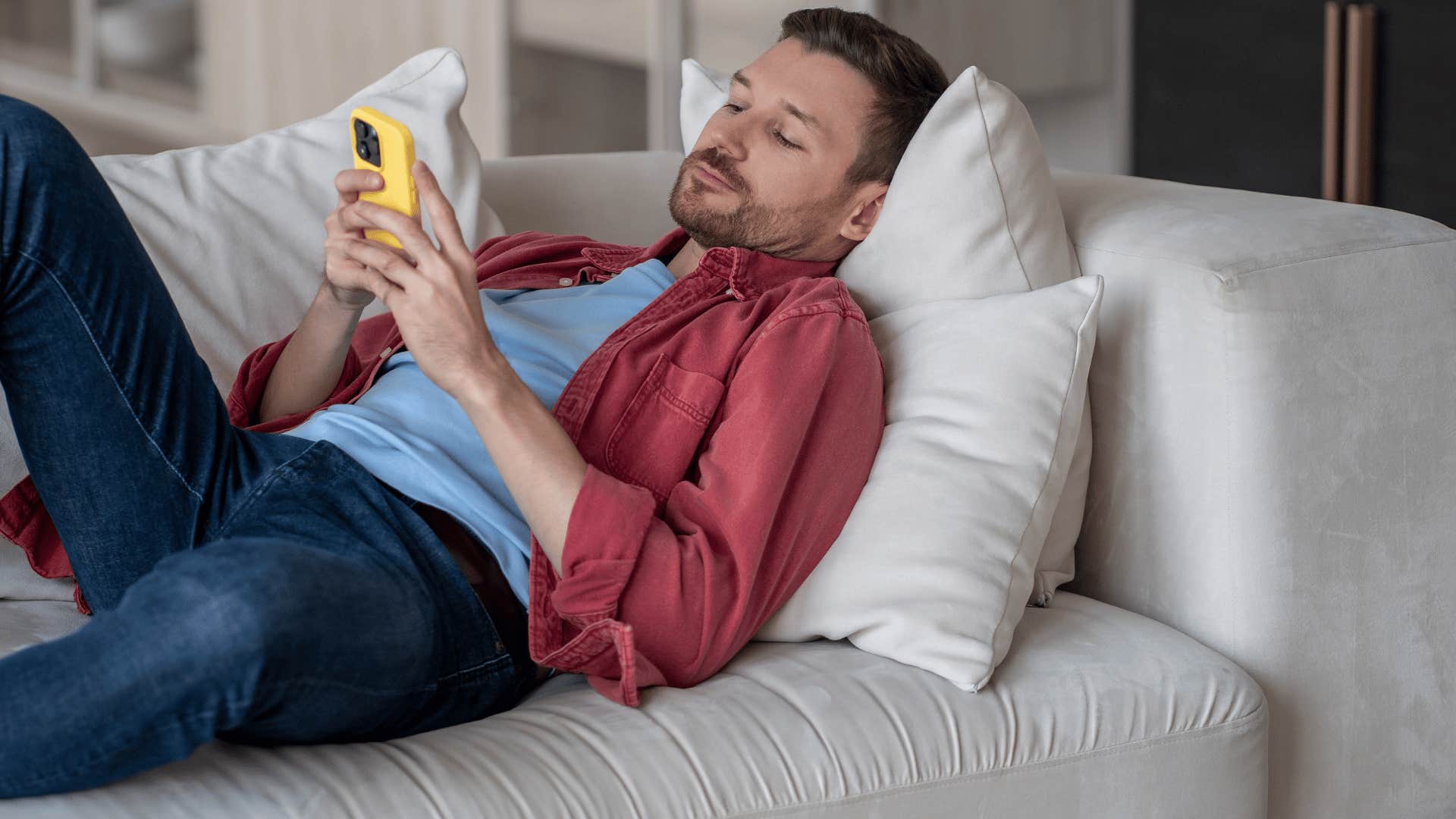 man in blue shirt complaining without taking action as he lazily scrolls on phone